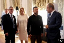 Polish Prime Minister Donald Tusk, right, talks to Ukrainian President Volodymyr Zelenskyy next to Britain's Prime Minister Keir Starmer, left, during the European Political Community meeting, near Oxford, England, on July 18, 2024.