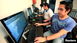 Colombian systems programmer Juan Pico works on the video game "Adios a las Armas" (Farewell to Arms) in Bogota, Sept. 4, 2014