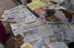 An Indian vendor arranges newspapers in Nepal at a newspaper stand in Siliguri on March 13, 2018.