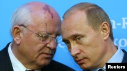 Russian President Putin listens to former President of the Soviet Union Gorbachev during news conference in Schleswig, Germany, December 21, 2004. 