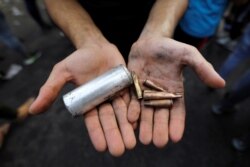 A demonstrator shows empty canisters that were used by Iraqi security forces during a protest over unemployment, corruption and poor public services, in Baghdad, Iraq, Oct. 2, 2019.