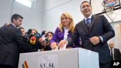 Romanian Prime Minister and candidate of the ruling Social Democracy Party (PSD), Victor Ponta, right, casts his ballot alongside his wife, Daciana Sarbu, in Bucharest, Romania, Nov. 2, 2014. 