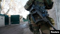 An armed French soldier secures the access to a Jewish school in Marseille's 9th district, France, Jan, 11, 2016, after a teenager, armed with a machete and a knife, wounded a teacher slightly before being stopped and arrested.