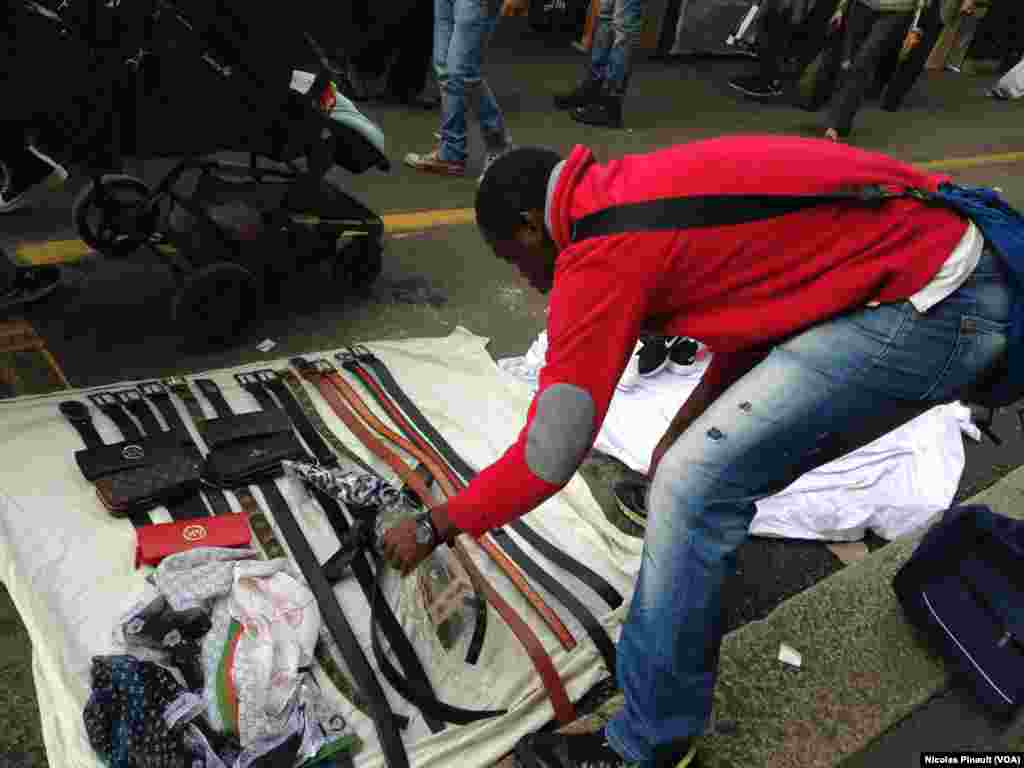 Un vendeur sénégalais installe sa marchandise au marché de Lima, Milan, 10 octobre 2015 (Nicolas Pinault/VOA)