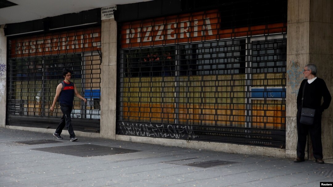 A man walks past closed restaurant during a blackout in Caracas, Venezuela, March 26, 2019. 
