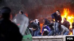 Para demonstran melemparkan batu ke arah polisi di Tirana, Albania, Jumat (21/1).
