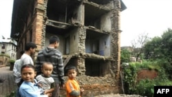 Trẻ em Nepal đứng cạnh một tòa nhà bị hư hại ở Katmandu sau trận động đất làm rung chuyển miền đông bắc Ấn Ðộ, ngày 19/9/2011