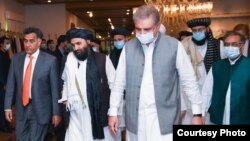 FILE - Mullah Abdul Ghani Baradar, center, then the Taliban's political affairs chief, heads for talks with then-Foreign Minister Shah Mehmood Qureshi, right, and then-Pakistani spy agency chief Faiz Hameed in Islamabad, Aug. 25, 2020.