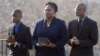 FILE - Isatu Salia carriers the cremated remains of her husband, Ebola victim Dr. Martin Salia, while their sons Maada Martin Salia, 20, right, and Hinwaii Sakatty Salia, 12, walk with her to enter St. Mary's Church in Landover Hills, Md., for a funeral Mass, Nov. 29, 2014.