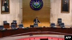 Un empleado desinfecta el salón principal de la Asamblea Legislativa salvadoreña durante un receso de su segunda sesión plenaria, en San Salvador, el 5 de mayo de 2021.