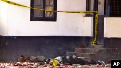 FILE - One of the bodies of three women who were shot dead by police lies outside the central police station in the coastal city of Mombasa, Kenya, Sept. 11, 2016.