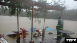 ফিলিপাইনের বাগুইওতে কোম্পাসুর আঘাতে সৃষ্ট বন্যায় আটকে পড়া একজন অধিবাসী- অক্টোবর ১২, ২০২১- রয়টার্স 