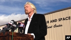 FILE - Billionaire Virgin Galactic founder Richard Branson salutes the bravery of test pilots during a news conference in Mojave, Calif., Nov. 1, 2014. Virgin Galactic announced a new version of its space tourism rocket.