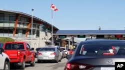 Lalu lintas kendaraan yang memasuki Kanada dari Amerika Serikat di Peace Arch Border Crossing, di Blaine, Washington, 9 Oktober 2019. 