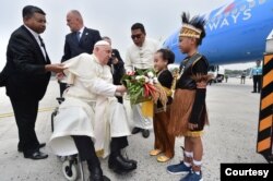 Paus Fransiskus menerima karangan bunga yang diberikan oleh dua orang anak berpakaian tradisional, Mary Lourdes Wicaksono Atmojo dan Irfan Wael setibanya di Bandara Internasional Soekarno Hatta, Tangerang, Banten, Selasa (3/9/2024).