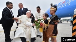 Paus Fransiskus menerima karangan bunga yang diberikan oleh dua orang anak berpakaian tradisional, Mary Lourdes Wicaksono Atmojo dan Irfan Wael setibanya di Bandara Internasional Soekarno Hatta, Tangerang, Banten, Selasa (3/9/2024). (INDONESIA PAPAL VISIT COMMITTEE/AGUS SUPARTO)