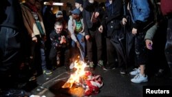 Pasca terpilihnya Donald Trump, beberapa warga AS melakukan protes di luar Trump Tower di New York, dengan membakar bendera Amerika, hari Rabu (9/11).