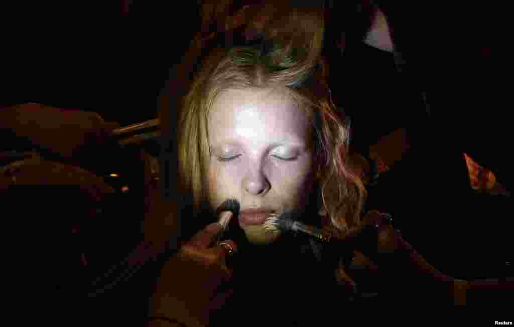 A model has her makeup and hair done backstage before the presentation of the Jonathan Saunders Spring/Summer 2015 collection during London Fashion Week.