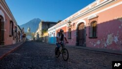 Un hombre pasa en su bicicleta cerca del arco de Santa Catalina en Antigua Guatemala. La ciudad ha estado cerrada al turismo a causa de la pandemia.