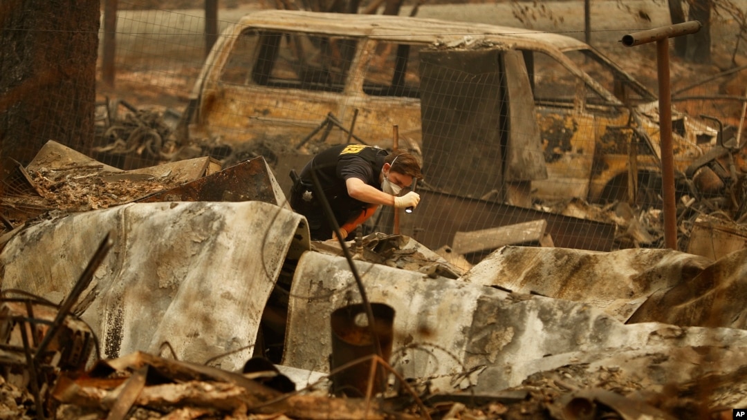 A member of the Sacramento County Coroner's office looks for human remains in the rubble of a house burned at the Camp Fire in Paradise, Calif., Nov. 12, 2018.