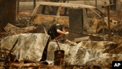 A member of the Sacramento County Coroner's office looks for human remains in the rubble of a house burned at the Camp Fire in Paradise, Calif., Nov. 12, 2018.