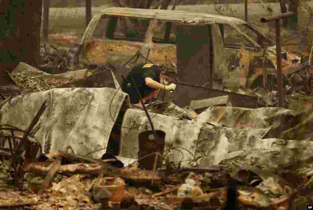 A member of the Sacramento County Coroner's office looks for human remains in the rubble of a house burned at the Camp Fire in Paradise, Calif., Nov. 12, 2018.