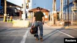 FILE - A steel worker heads to work at U.S. Steel Granite City Works, in Granite City, Illinois, May 24, 2018.