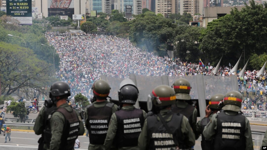 FILE - Venezuelan National Guard members watch anti-government marchers trying to make their way to the National Assembly in Caracas, Venezuela, May 3, 2017.