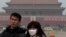 A woman wears a mask as she visits Tiananmen Square in Beijing, Jan. 13, 2013.