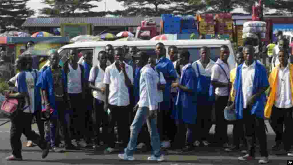 Une scène de gnes qui attendent un moyen de transport à Kinshasa. Une partie importante du transport est assurée par les conducteurs des taxi-motos accusés d&#39;être des membres des gangs que la police a visés. (AP Photo/Saul Loeb, Pool) 