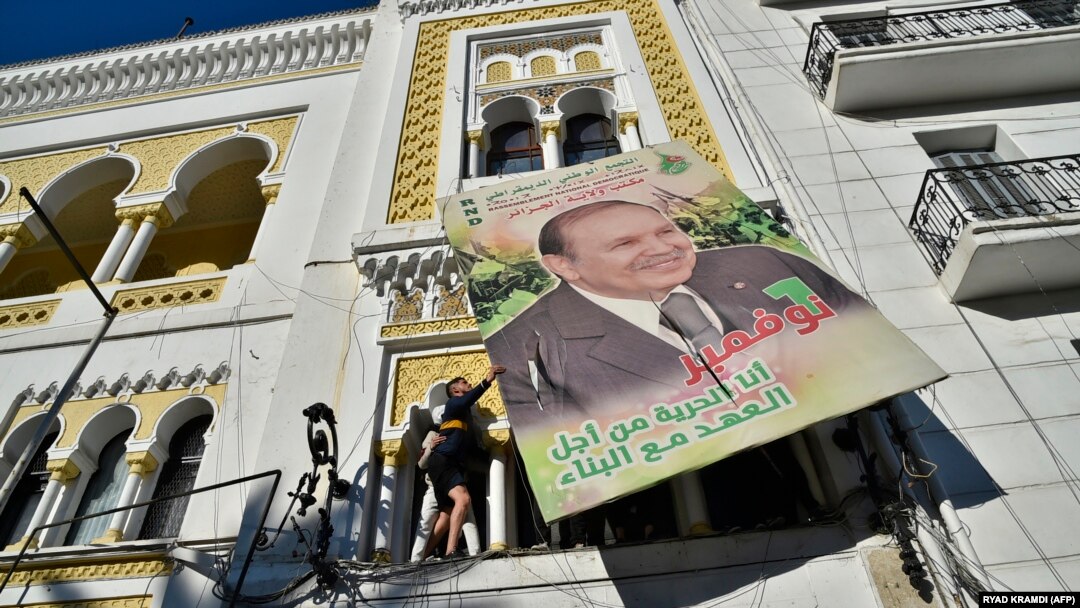 Abigaragambya bahanuye icyapa cyariho ifoto ya Perezida Abdelaziz Buteflika.