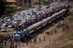 Sudanese civilians ride on the train to join the celebrations of the signing of the power sharing deal, that paves the way for a transitional government, in Khartoum, Aug. 17, 2019.
