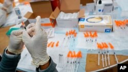 FILE - A registered nurses fills a syringe with the Johnson & Johnson COVID-19 vaccine at a pop-up vaccination site at the Albanian Islamic Cultural Center in the Staten Island borough of New York, April 8, 2021.