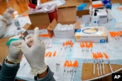 FILE - A registered nurse fills a syringe with the Johnson & Johnson COVID-19 vaccine at a pop-up vaccination site at the Albanian Islamic Cultural Center in the Staten Island borough of New York, April 8, 2021.