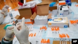 FILE - A registered nurses fills a syringe with the Johnson & Johnson COVID-19 vaccine at a pop-up vaccination site at the Albanian Islamic Cultural Center in the Staten Island borough of New York, April 8, 2021.