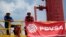 ARCHIVO - Trabajadores petroleros en una plataforma petrolera operada por la empresa estatal venezolana PDVSA, en Morichal, en julio de 2011.