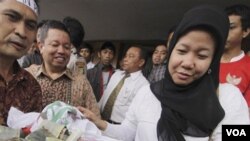 Prita Mulyasari (kanan) menerima bantuan dana dari pendukungnya setelah sidang di pengadilan Tangerang, Desember 2009. (Foto: Dok)