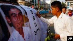 File Photo: A Cambodian worker gives a signature on a poster of Chea Vichea during the 11th anniversary of assassination of Chea Vichea, former head of Cambodia's Free Trade Union of Workers, in Phnom Penh, Cambodia, Thursday, Jan. 22, 2015. (AP Photo/Heng Sinith)