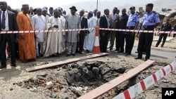 Le président Goodluck Jonathan (au c. avec le chapeau noir) visite l'église Sainte Thérèse, près d'Abuja, qui a été attaquée le jour de Noël (31 déc. 2011)