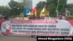 Para pengunjuk rasa membawa spanduk yang menyuarakan protes terhadap IMF-World Bank (Bank Dunia) di depan Kedutaan Bank AS, Jakarta, 8 Oktober 2018. (Foto: VOA/Ahmad Bhagaskoro)