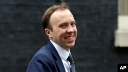 FILE - In this Jan. 9, 2018 file photo, Secretary of State for Digital, Culture, Media and Sport Matt Hancock smiles after leaving a Cabinet meeting in London. 