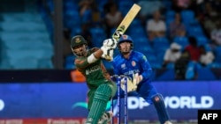 Bangladesh's Liton Das (L) hits four as Afghanistan's Mohammad Ishaq (R) looks on during the ICC men's Twenty20 World Cup 2024 Super Eight cricket match between Afghanistan and Bangladesh at Arnos Vale Stadium in Arnos Vale, Saint Vincent and the Grenadin