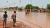 Des enfants marchent dans une rue inondée de Niamey le 15 juin 2017.