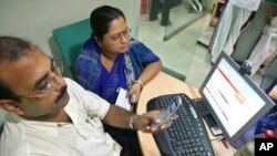 A man sends a text message from his mobile phone inside an Internet cafe in the eastern Indian city of Kolkata (file photo)