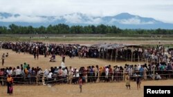 Rohingya refugees line up to receive food at a camp near Teknaf, Bangladesh, Oct. 12, 2017.