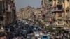 FILE - People crowd a street a few hours ahead of curfew in Cairo, Egypt, April 14, 2020. security agencies have tried to stifle criticism about the handling of the coronavirus pandemic by the government of President Abdel Fattah el-Sissi.