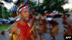 Des indigènes exécutant une danse rituelle lors d'une manifestation contre la décision du gouvernement de ne pas reconnaître la démarcation des terres des peuples indigènes de Raposa Serra do Sol, dans l'État de Roraima, Brasilia, 25 avril 2018.