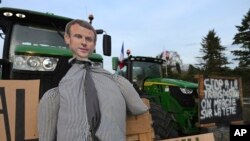 En la toma los manifestantes aluden al presidente francés Emmanuel Macron en un tractor mientras bloquean una carretera, el lunes 29 de enero de 2024, cerca de Roissy-en-France, al norte de París.
