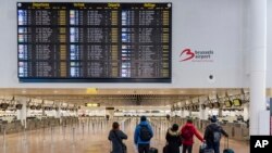 Penumpang melihat layar informasi keberangkatan di ruang keberangkatan yang sepi di Bandara Zaventem, Brussels, Rabu, 13 Februari 2019.