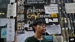 香港学民思潮召集人黄之锋在香港政府总部前面。一个名为“匿名”(Anonymous)的网上团体威胁攻击香港政府网站 